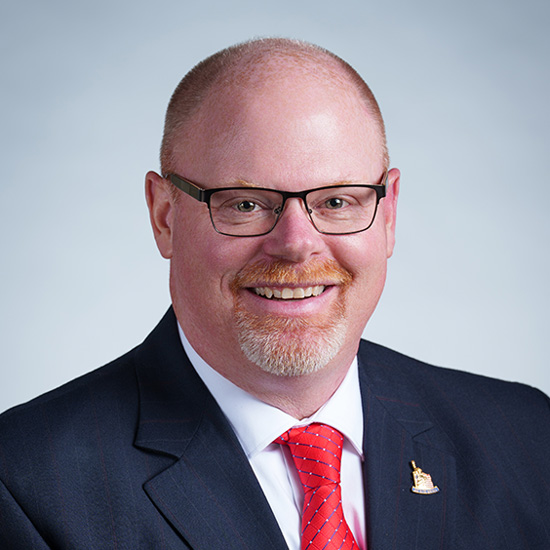 Chuck Heit standing in front of american flag